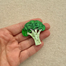 Load image into Gallery viewer, Green broccoli-shaped brooch being held on a beige fabric background