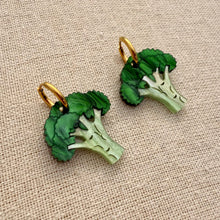 Load image into Gallery viewer, Two green broccoli-shaped earrings on a beige fabric background