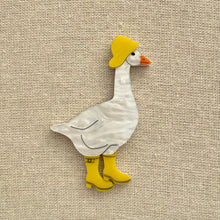 Load image into Gallery viewer, Acrylic goose brooch wearing a yellow hat and boots on a textured beige background