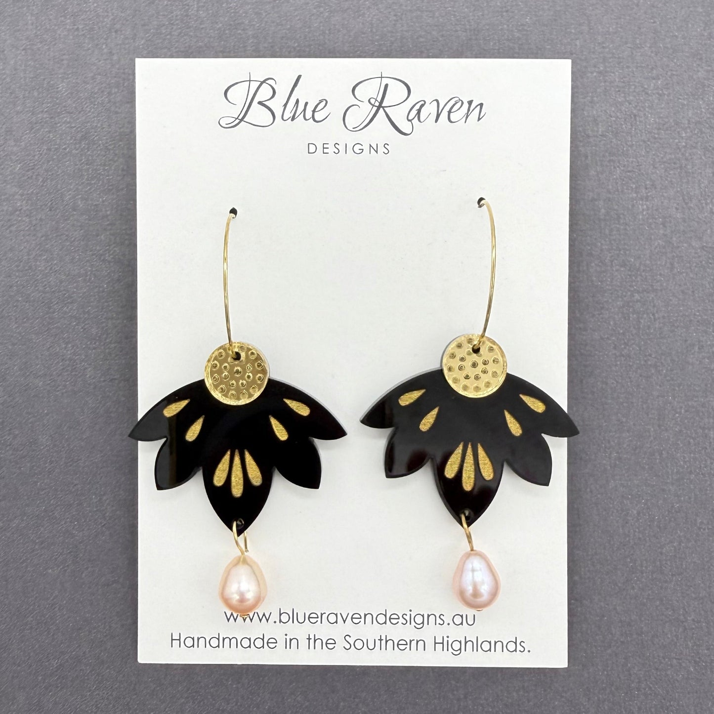Black and gold earrings on a Blue Raven Designs card with a gray background