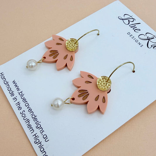 Pair of pink leaf-shaped earrings with gold accents and pearl-like beads on a Blue River Designs card.