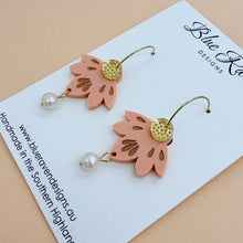 Load image into Gallery viewer, Pair of pink leaf-shaped earrings with gold accents and pearl-like beads on a Blue River Designs card.
