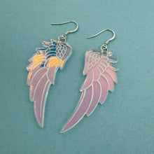 Load image into Gallery viewer, Pair of angel wing earrings on a teal background
