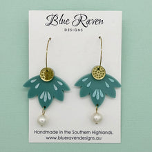 Load image into Gallery viewer, Teal earrings with gold and pearl details on a Blue Raven Designs card against a light green background.
