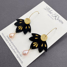 Load image into Gallery viewer, Black floral earrings with gold accents and pearl-like beads on a Blue Raven Designs card.
