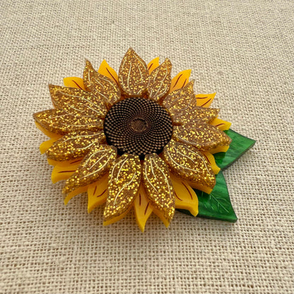 Decorative sunflower with glittery petals on a textured beige background